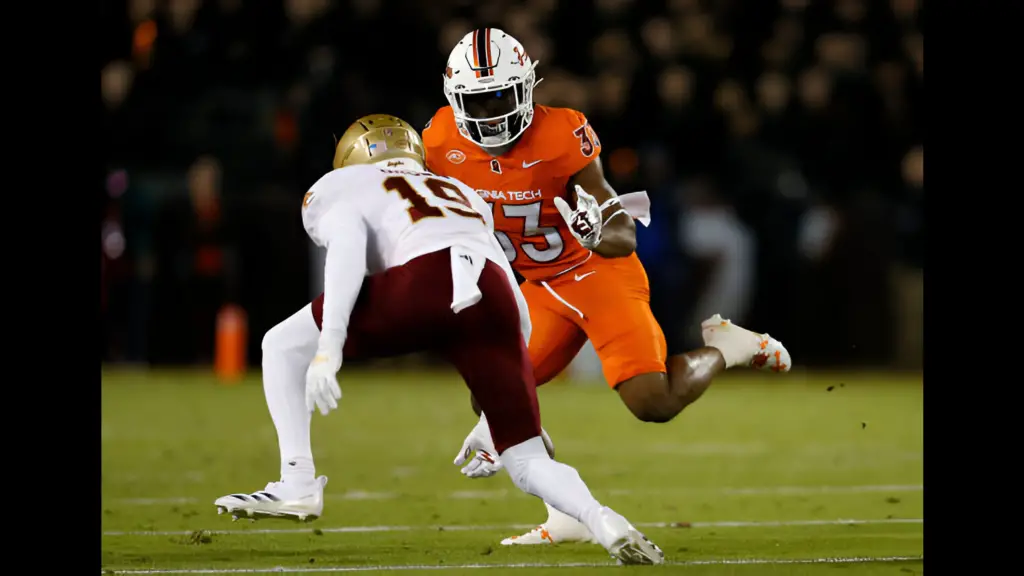 Virginia Tech Hokies running back Bhayshul Tuten rushes upfield attempting to evade Boston College Eagles defensive back Bryquice Brown during a college football game between the Boston College Eagles and the Virginia Tech Hokies