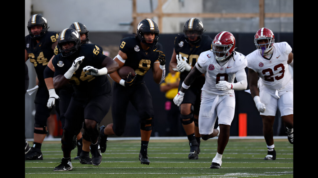 Vanderbilt Commodores tight end Eli Stowers runs with the football after making a play in front of Alabama Crimson Tide defensive back DeVonta Smith