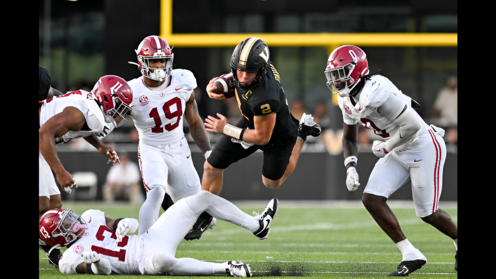 Vanderbilt Commodores quarterback Diego Pavia runs with the football and leaps over Malachi Moore against the Alabama Crimson Tide during the second half