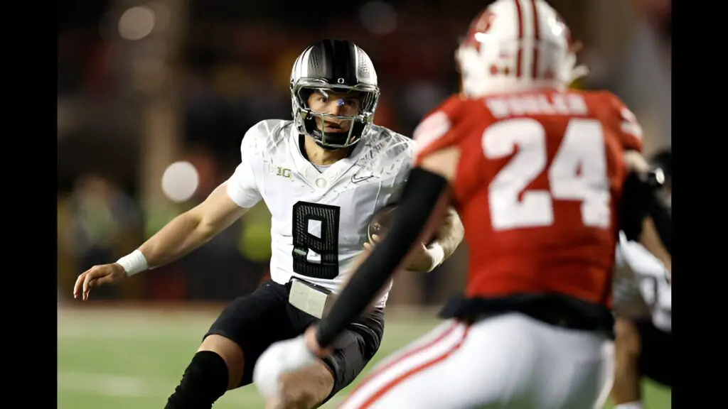 Oregon Ducks quarterback Dillon Gabriel runs with the ball for a first down late in the game against the Wisconsin Badgers