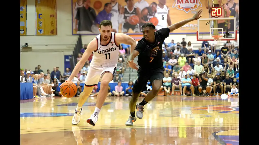 UCONN Huskies star Alex Karaban drives to the basket by PJ Carter against the Memphis Tigers in the second half during the Maui Invitational college basketball game