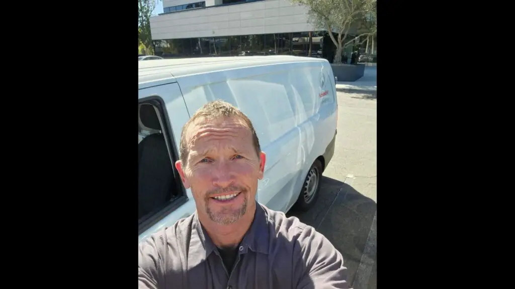 Funny Car driver Jack Beckman outside of his work van 