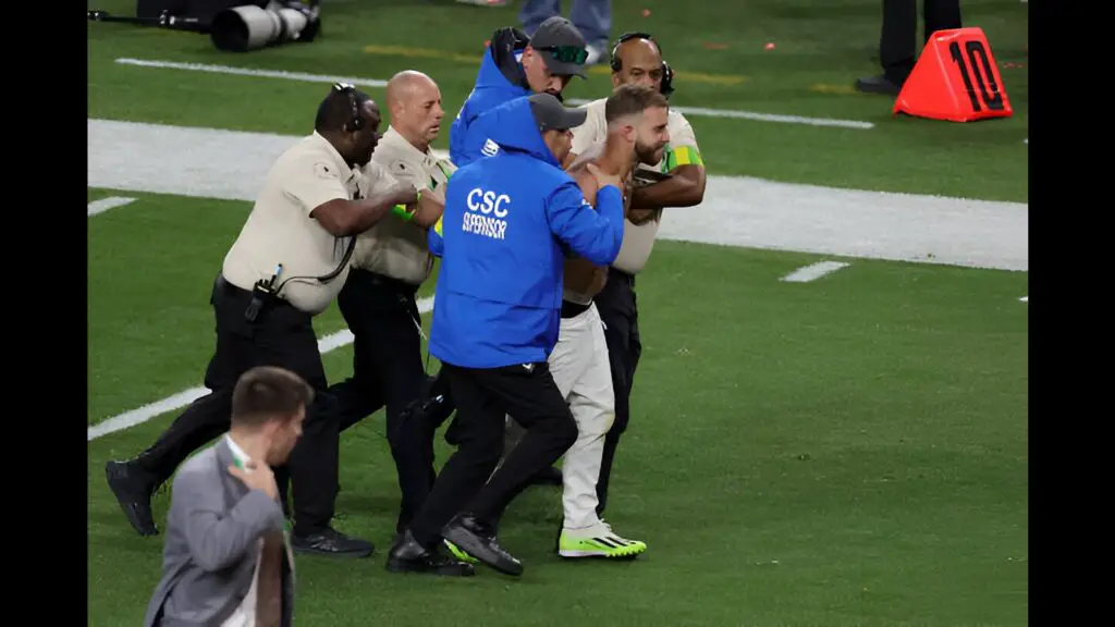 Fan Alex Gonzalez is escorted away by security guards after running onto the field in the third quarter during Super Bowl LVIII between the San Francisco 49ers and Kansas City Chiefs