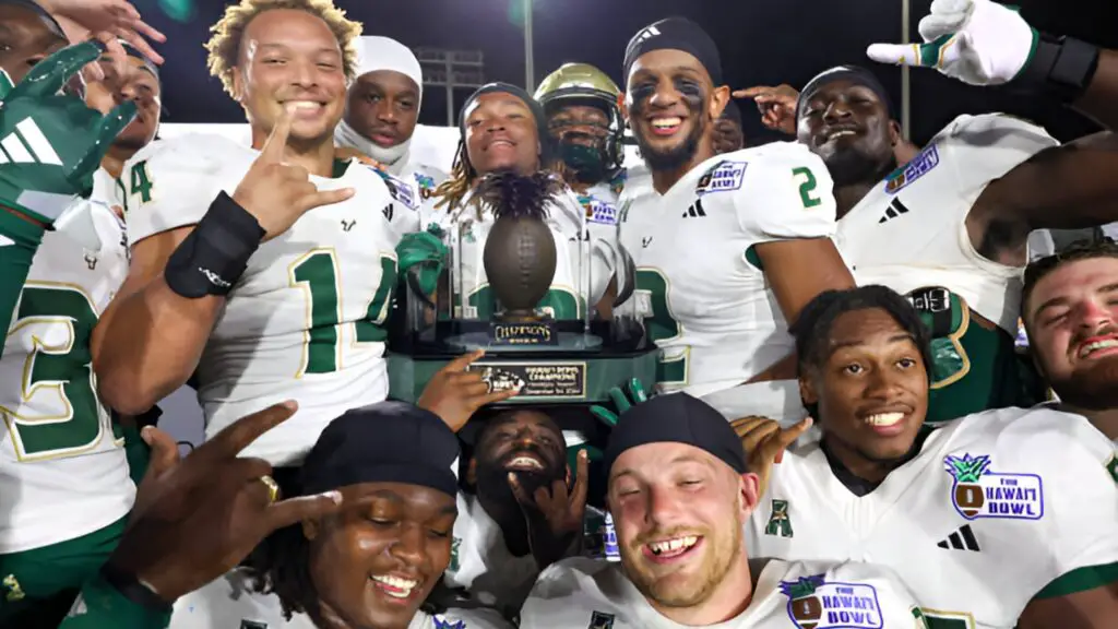 The South Florida Bulls players pose for a photo with the championship trophy after winning the Hawai’i Bowl against the San Jose Spartans