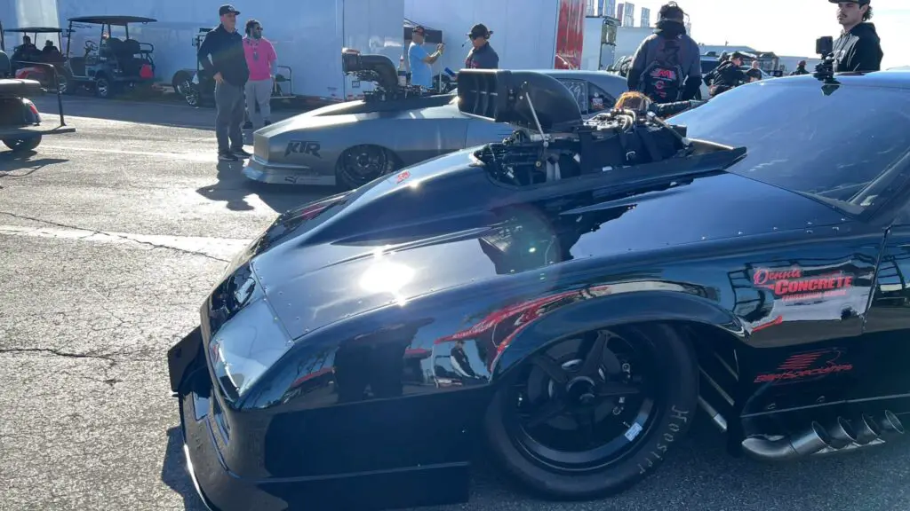 Drag racers Kye Kelley’s car and Stevie Fast Jackson’s car are lined up next to each other before their first round matchup