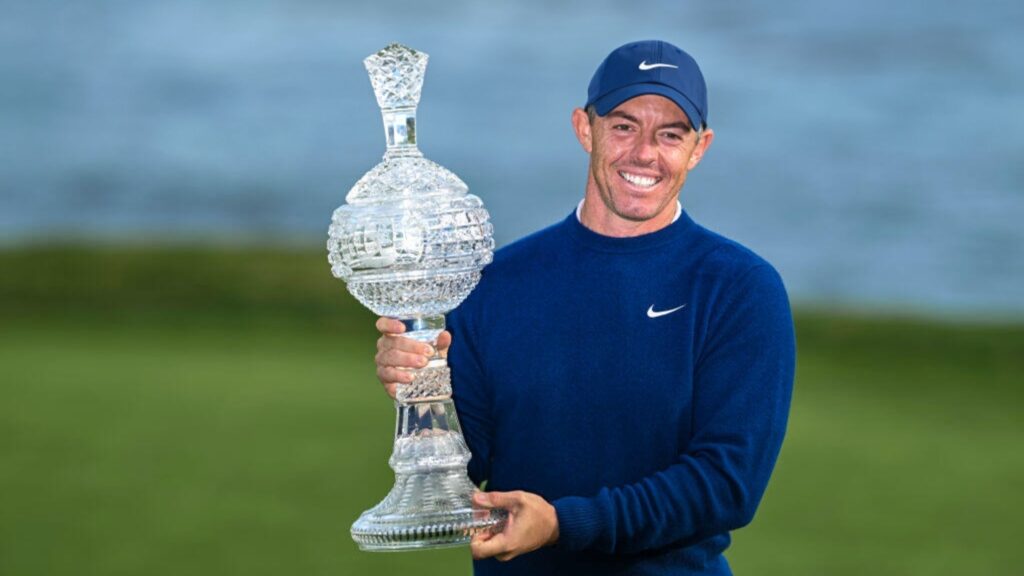 Golfer Rory McIlroy smiles with the tournament trophy following his two stroke victory in the final round of the AT&T Pebble Beach Pro-Am at Pebble Beach Golf Links