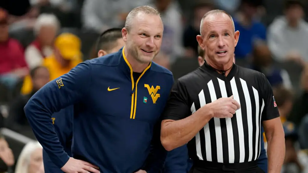 Former West Virginia men's basketball head coach Darian DeVries talks with an official in the first half during the second round game of the Big 12 men's basketball tournament