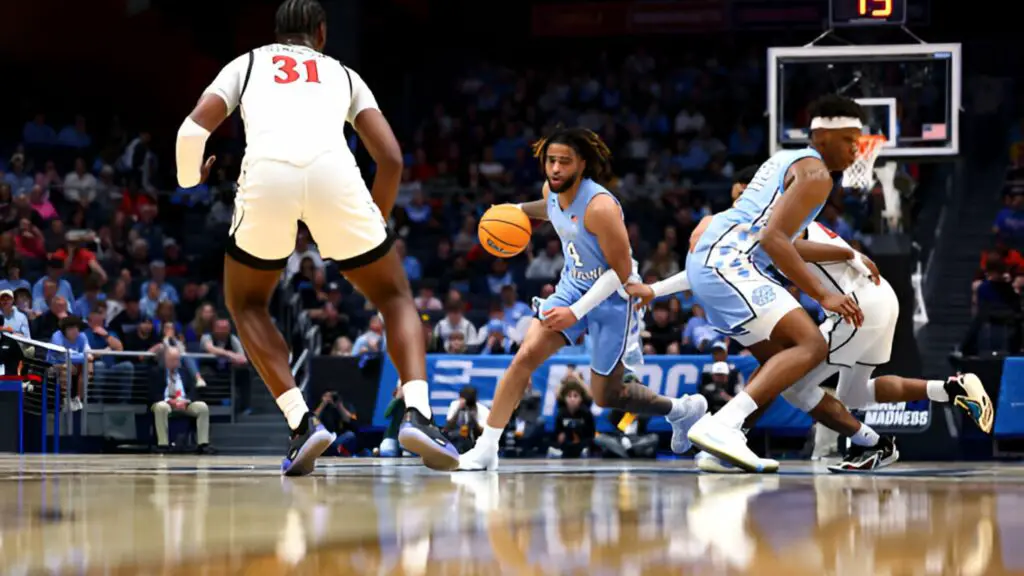 North Carolina Tar Heels senior RJ Davis moves past the San Diego State Aztecs defenders during the First Four round of the 2025 NCAA Men's Basketball Tournament 